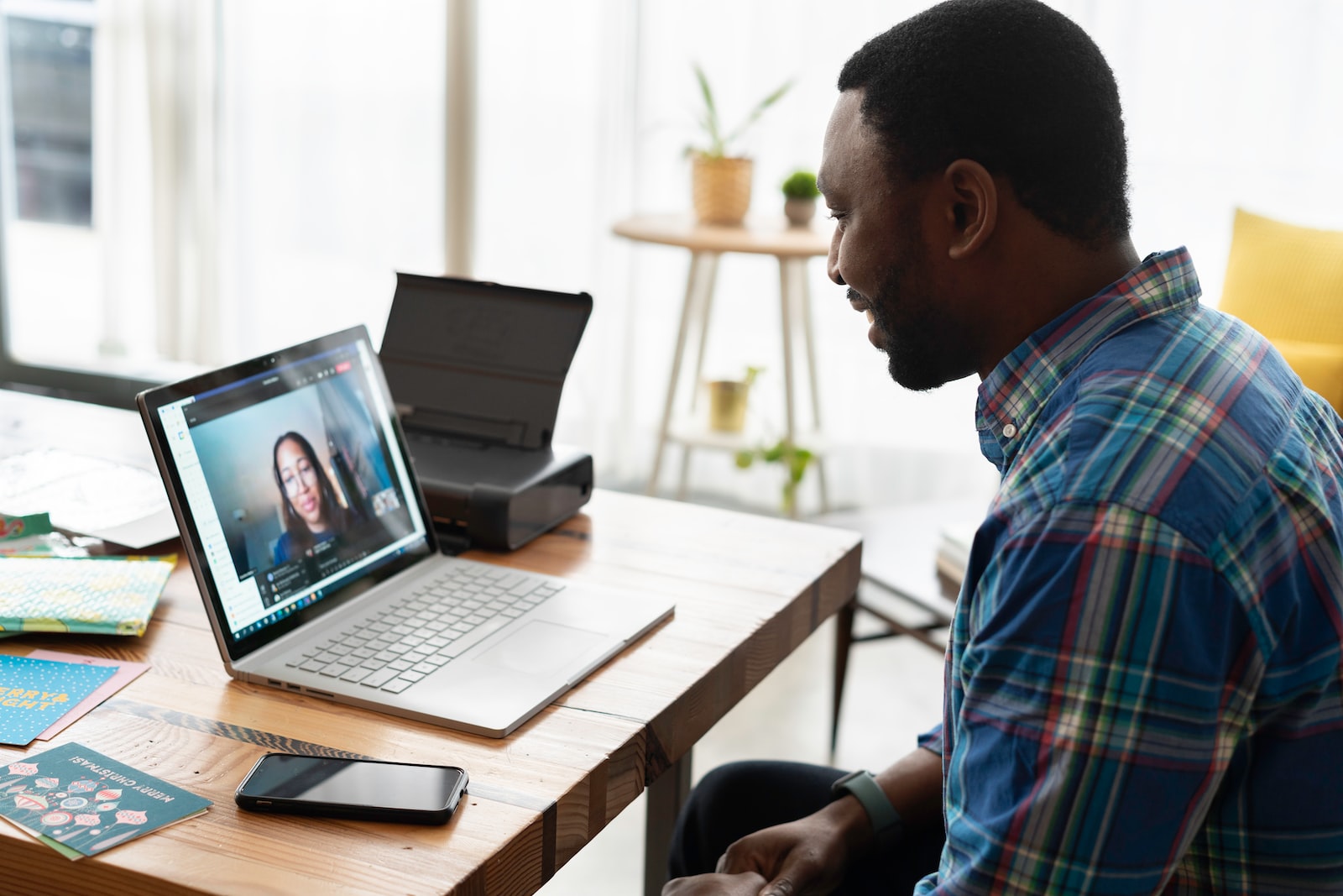 man in blue and white plaid dress shirt using macbook pro